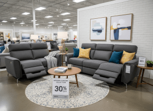 A modern reclining sofa and loveseat set in a cozy living room, dark gray fabric, furniture store display